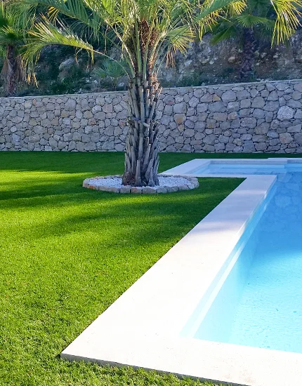 Un contour de piscine et gazon synthétique