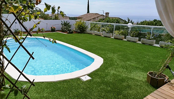 Contours de piscine en pelouse artificielle avec vue dégagée sur la mer